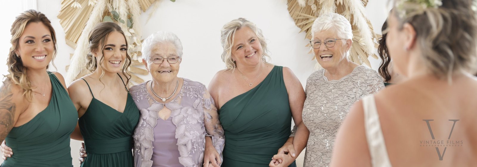 Her bridesmaids, mom and grandmothers seeing the bride for the first time